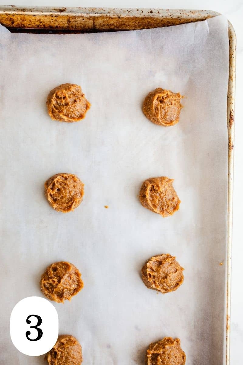 Cookie dough balls on a baking sheet.