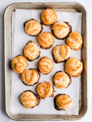 Coconut macaroons on a baking sheet lined with parchment.