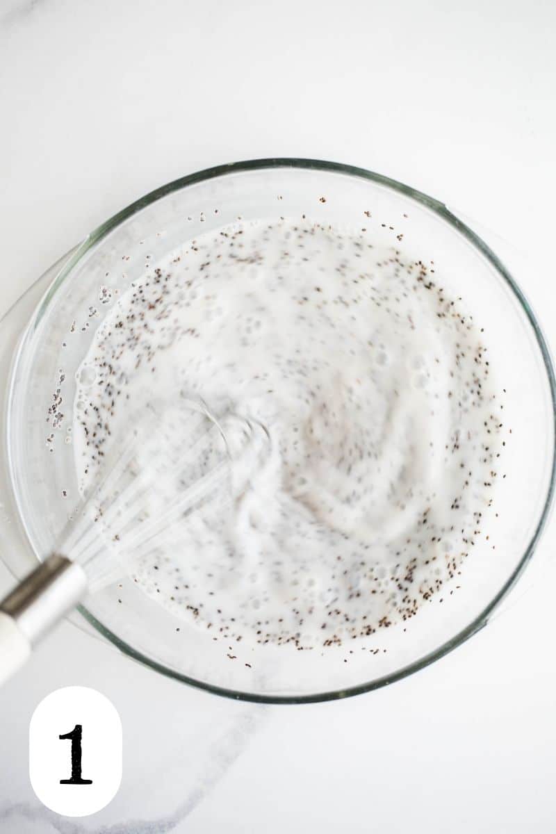 Chia and milk mixture being whisked together in a glass bowl. 