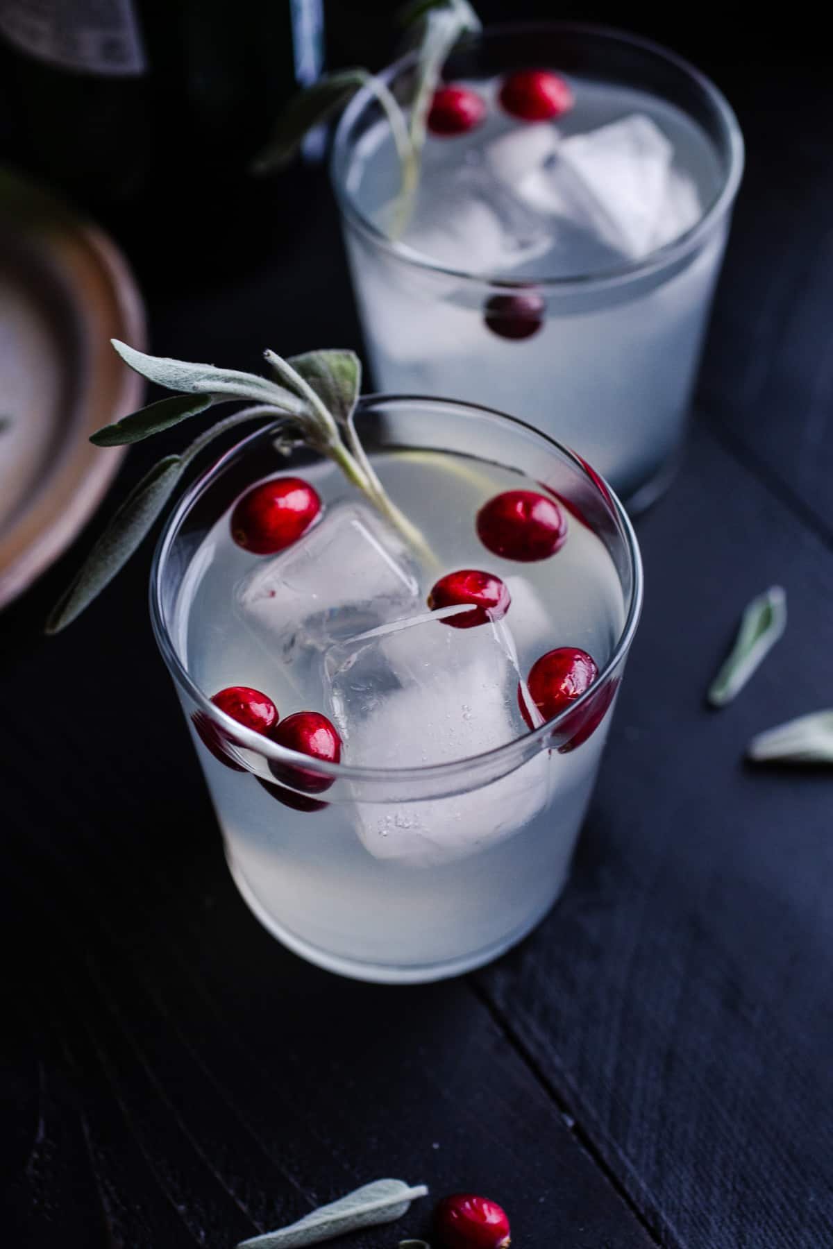 A cranberry gin cocktail with sage and cranberries.