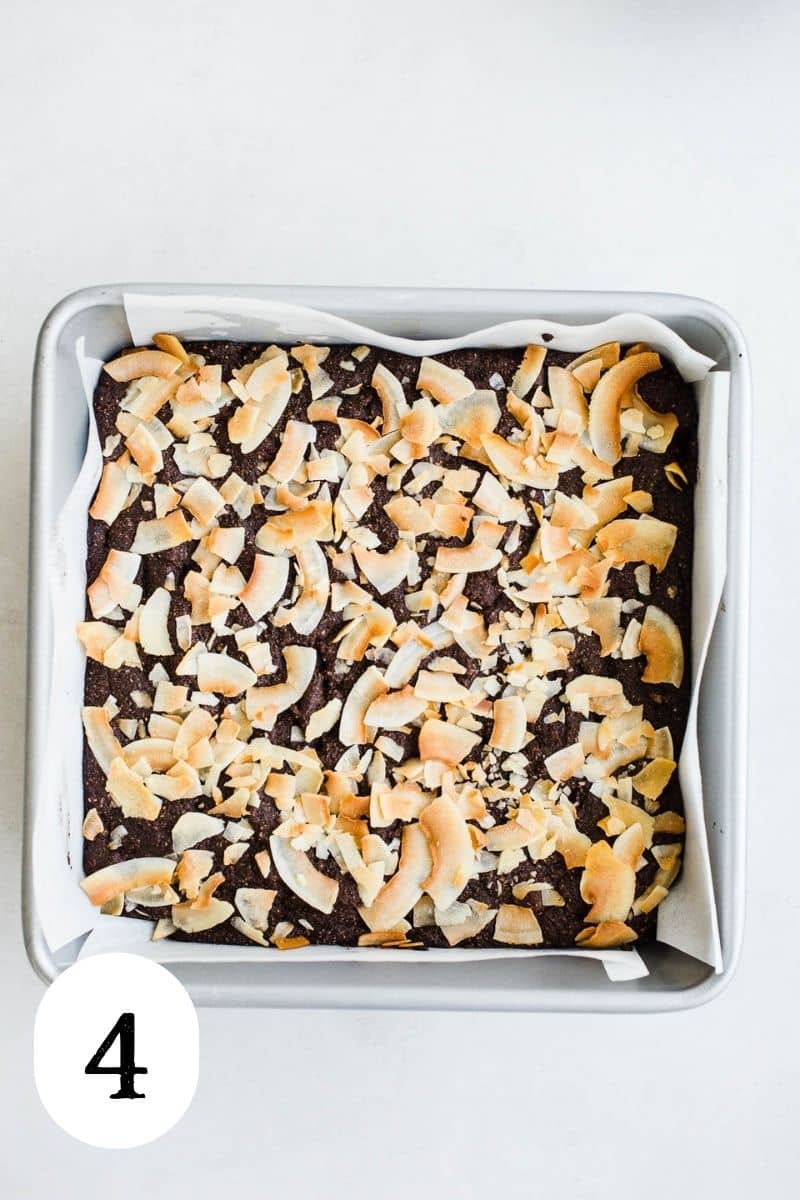 Baked brownies with coconut in a square pan.