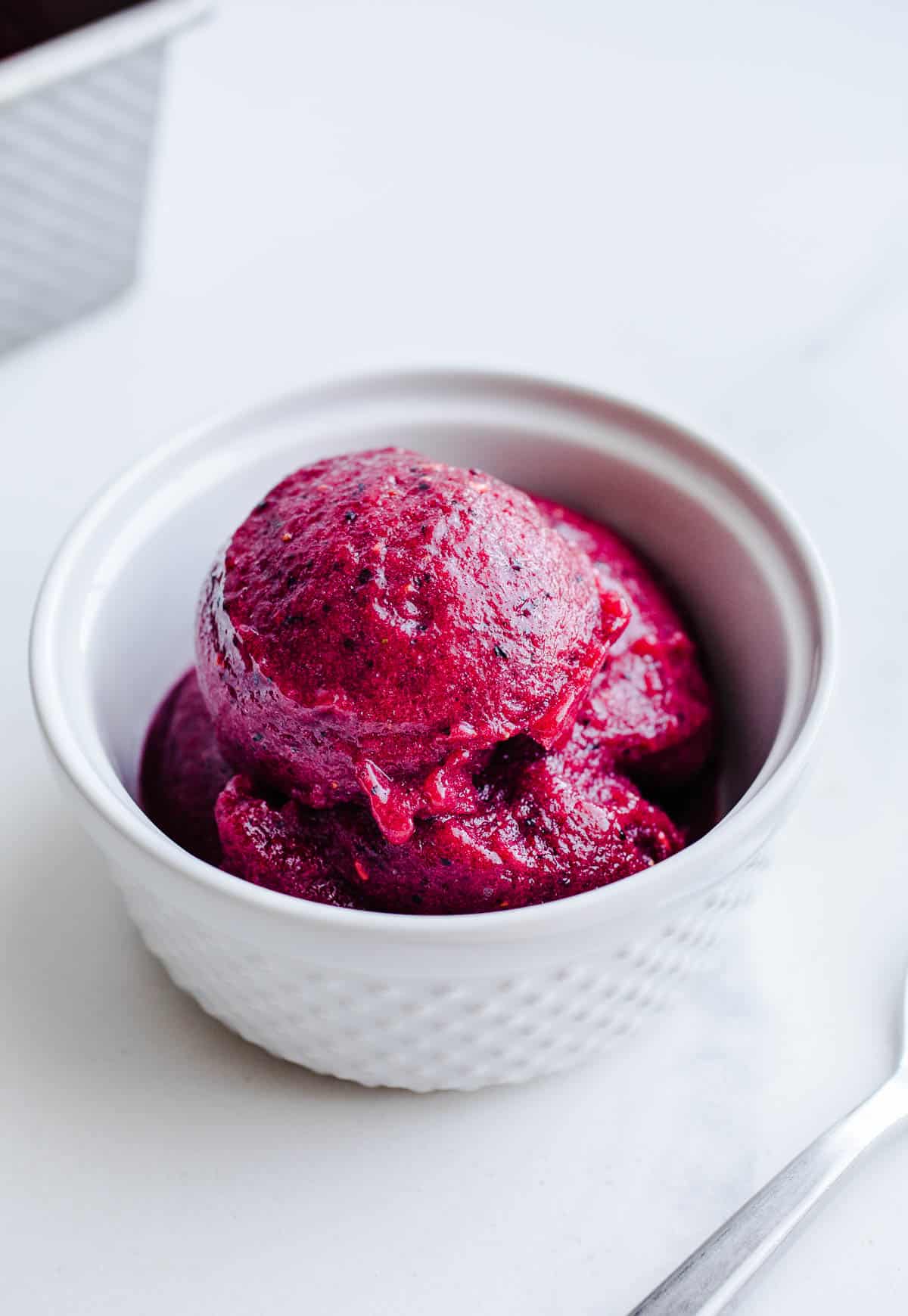 Pink sorbet in a small white bowl.