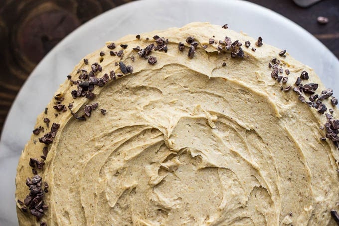 frosted cake topped with cacao nibs