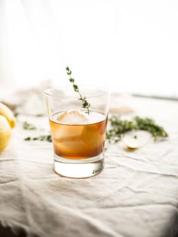 old fashioned cocktail with thyme garnish