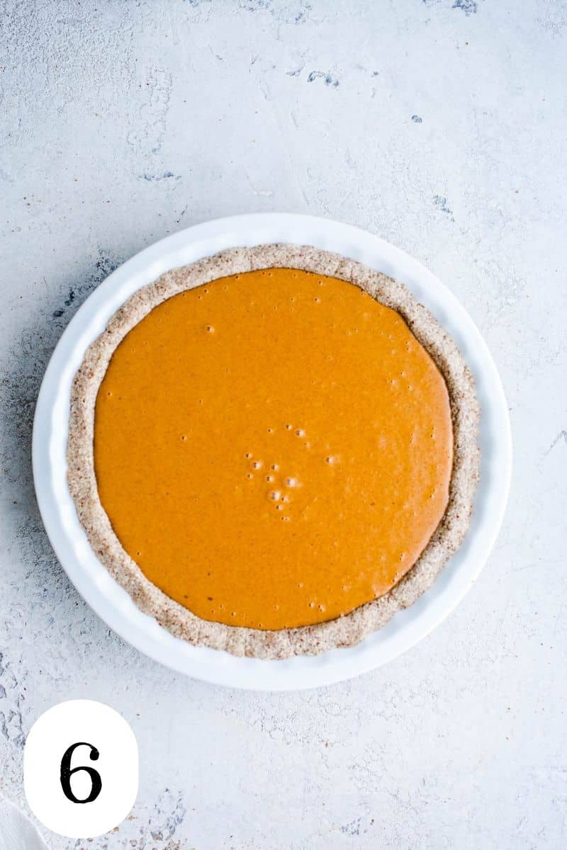 Uncooked carrot pie in white pie dish.