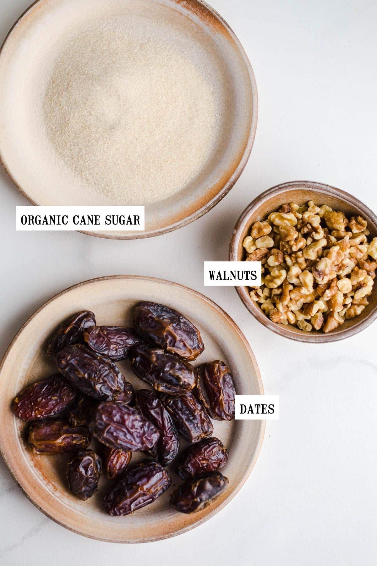 Ingredients for sugared dates laid out on a marble surface.