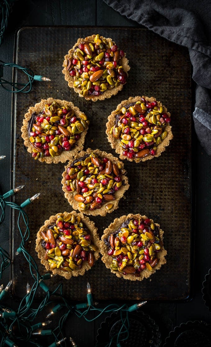 Gluten-free Christmas desserts including tarts with nuts on baking sheet. 
