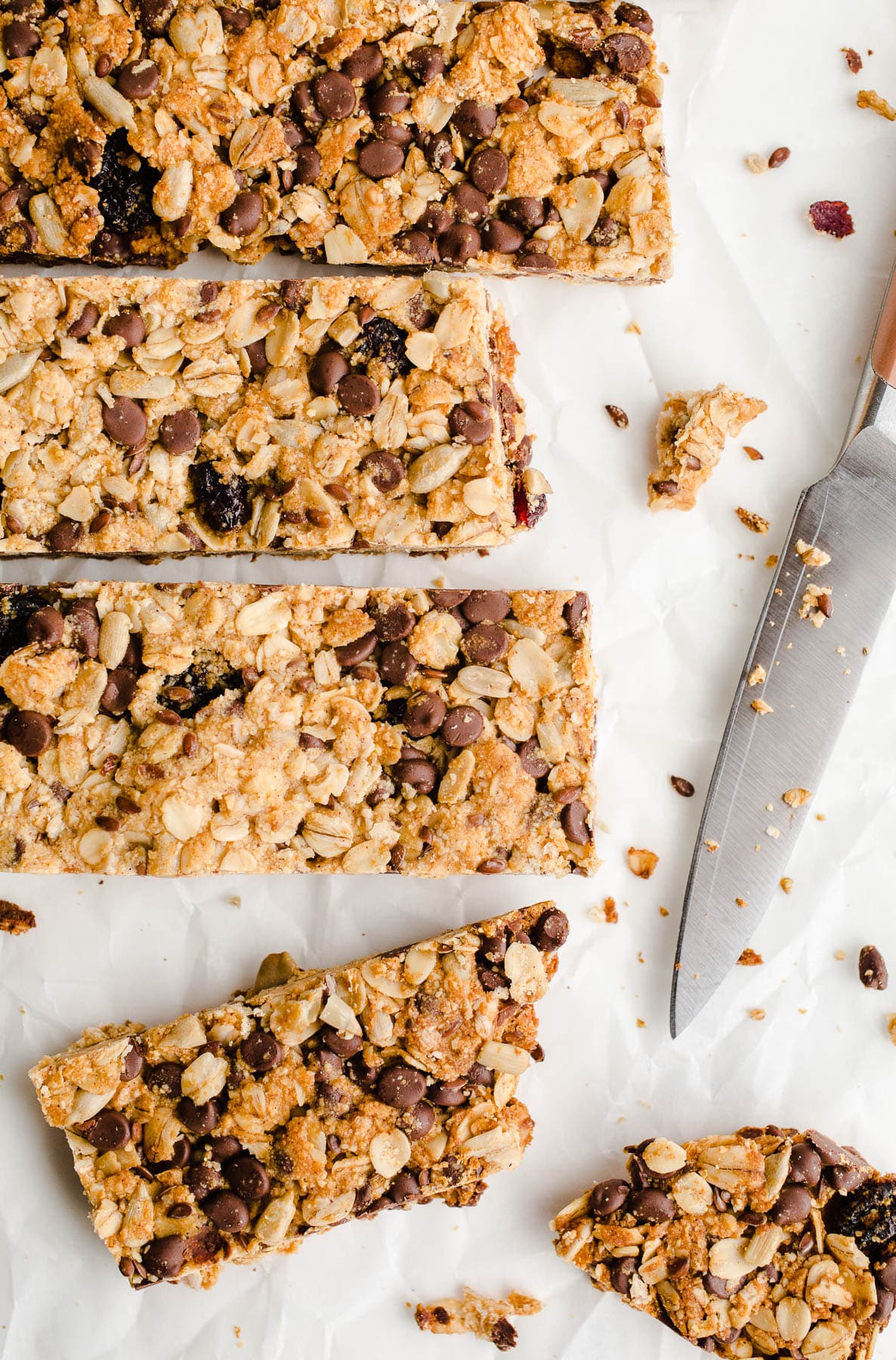 Freshly cut homemade granola bars on white parchment.