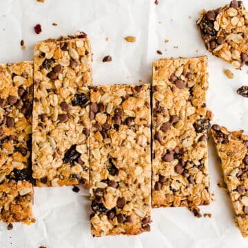Granola bars lined up in a row on a piece of white parchment paper.