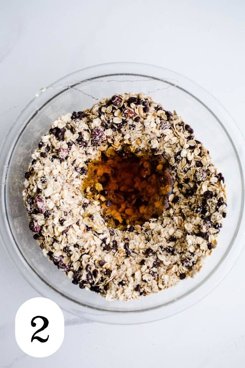 Honey in the center of an oat mixture in a glass bowl.