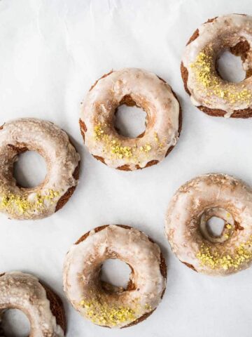 Glazed donuts topped with pistachios.