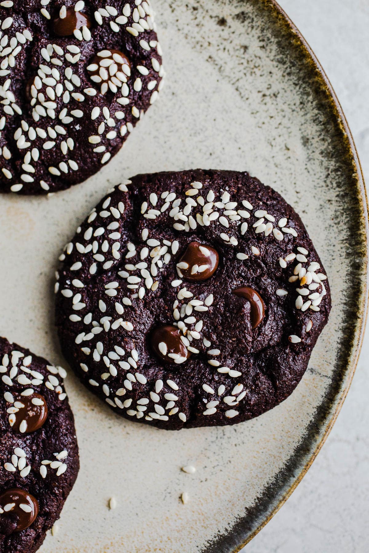 Chocolate cookies with sesame seeds on a plate. 