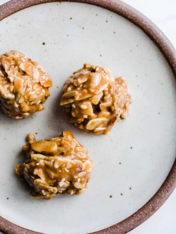 Three honey almond bites on a small rustic plate.