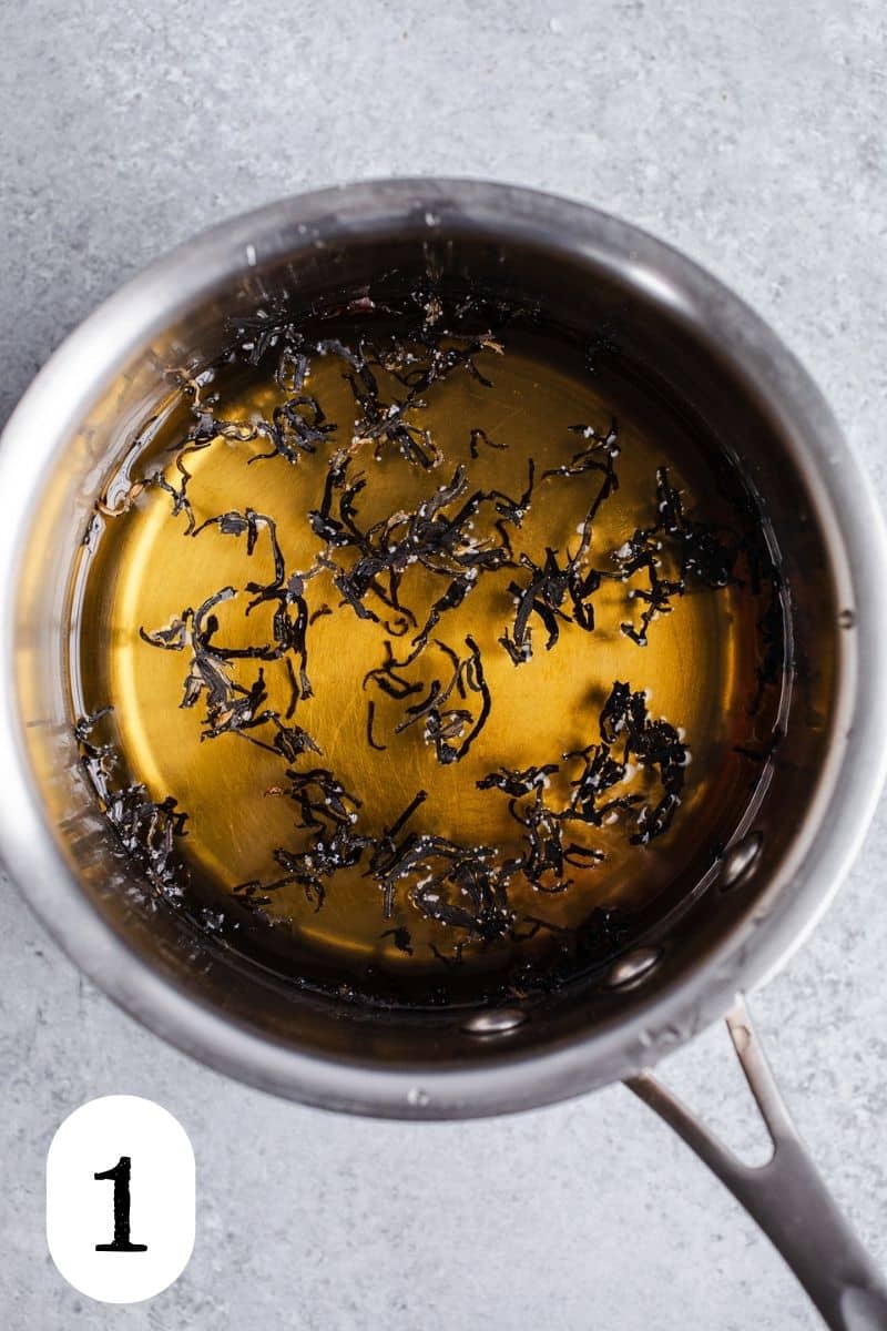 Loose leaf tea in sugar syrup in a saucepan.