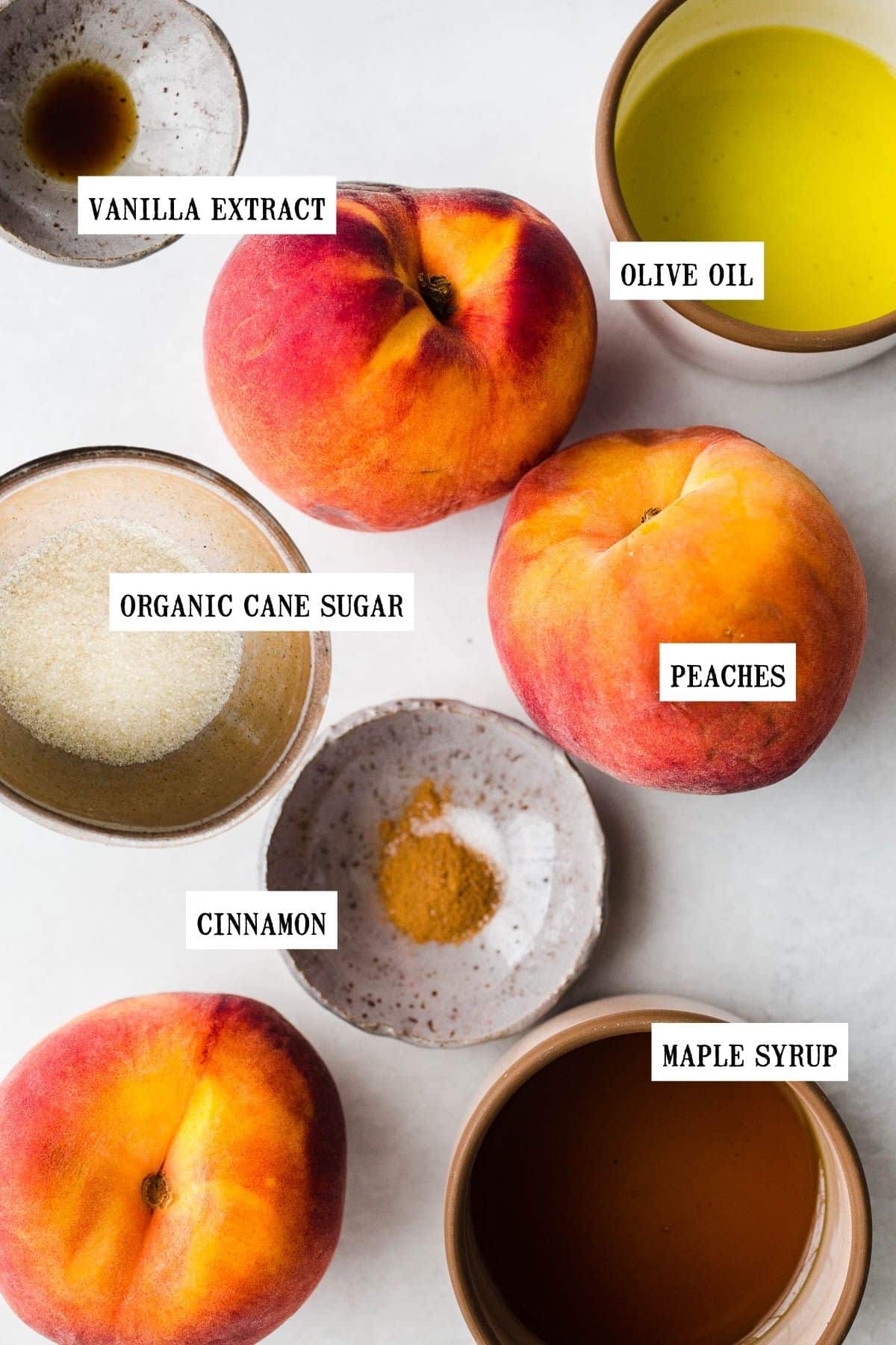 Ingredients to make air fryer peaches on a white surface. 