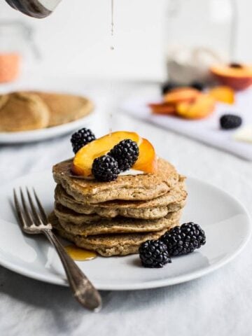 A stack of pancakes topped with fruit.