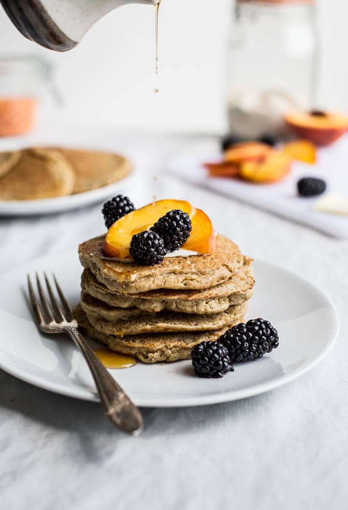 A stack of pancakes topped with fruit.