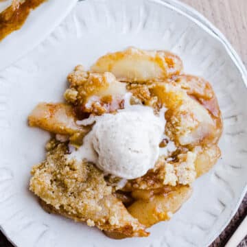 A serving of pear crumble on a white plate.