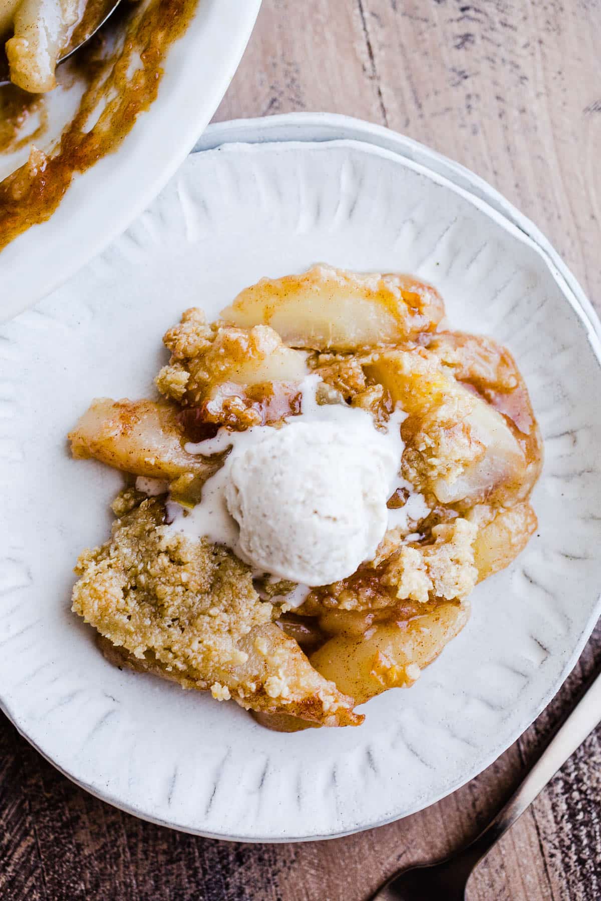 A serving of pear crumble on a white plate. 