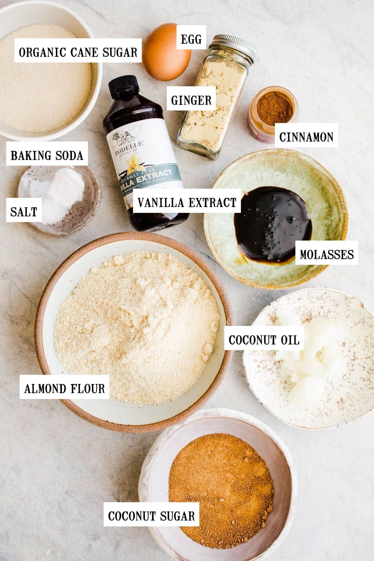 Ingredients to make gingersnap cookies in small bowls. 