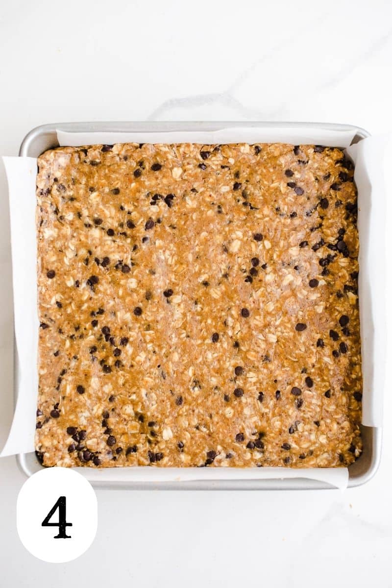 Peanut butter oat dough pressed into a square pan.