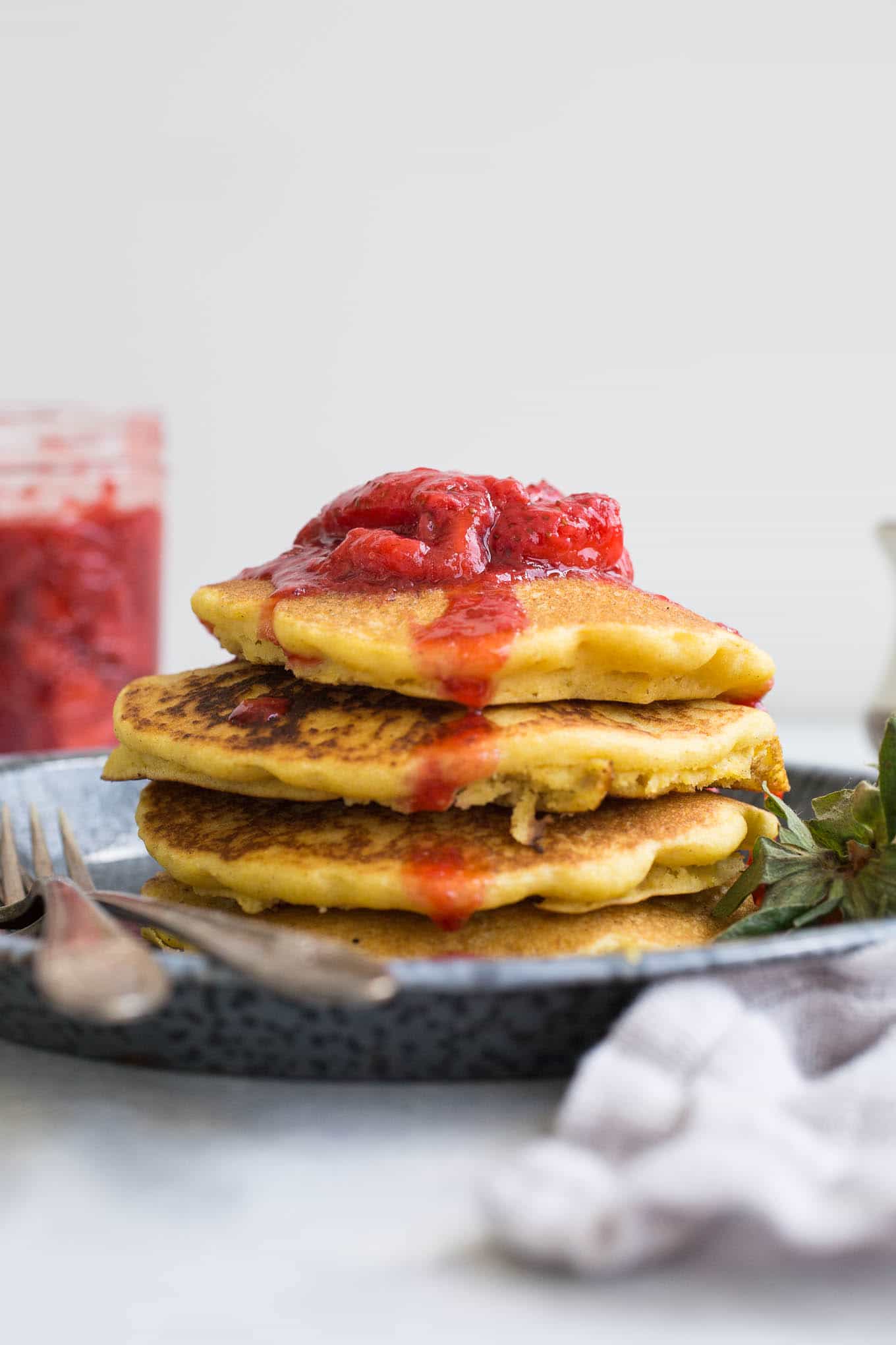 corn flour pancake stack with strawberry compote on top.