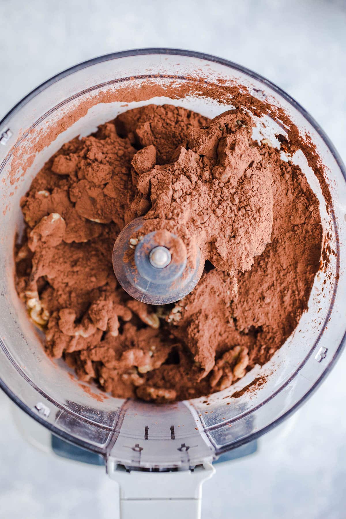 Cocoa powder and walnuts in a food processor.