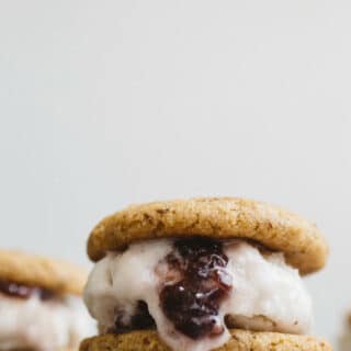 Soft and chewy, maple-sweetened peanut butter cookies sandwiched around homemade vegan jam ice cream. Gluten-free, vegan, and refined sugar-free.