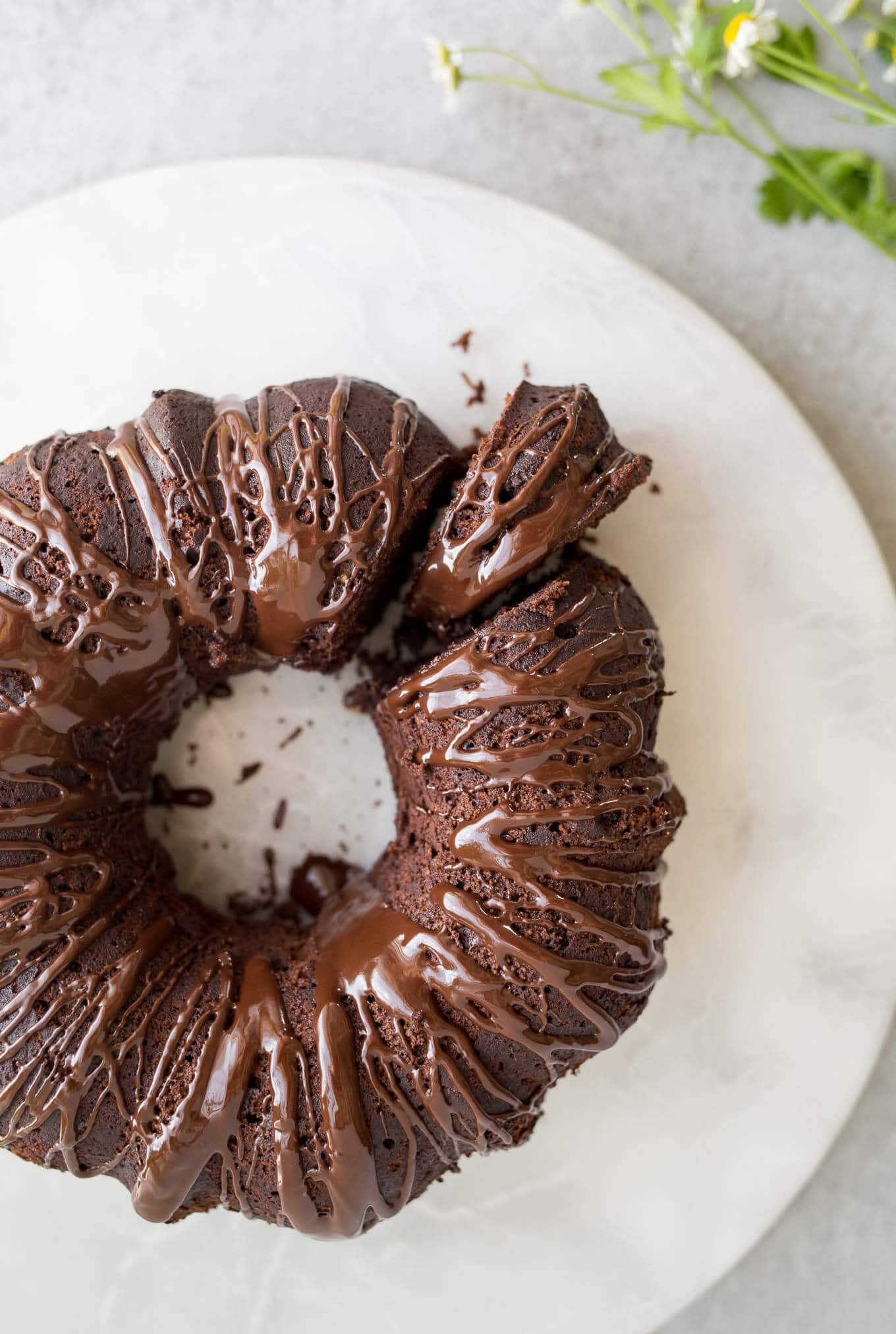 A chocolate bundt cake with chocolate drizzle on top.