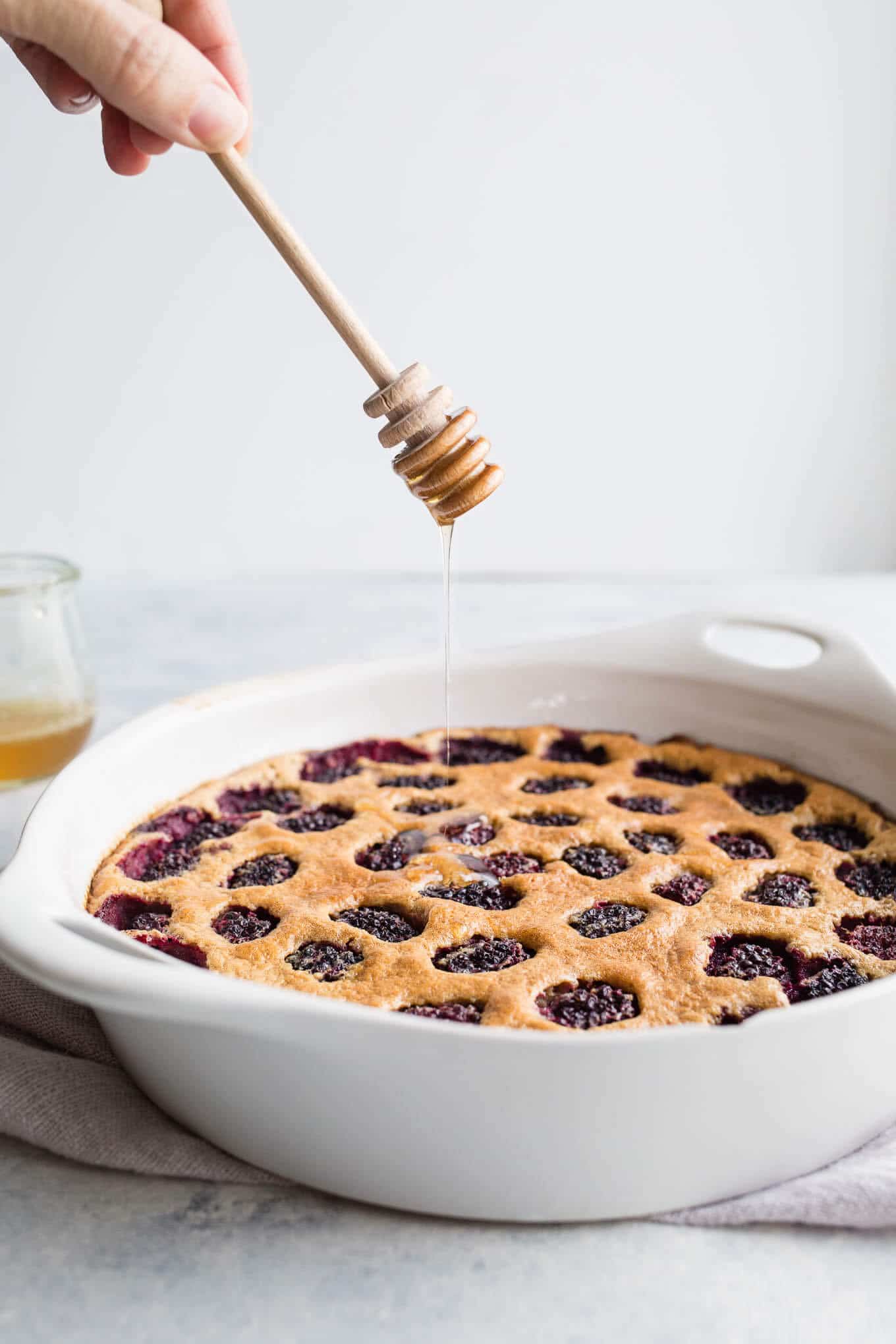 This Blackberry Honey Clafoutis is made with gluten-free almond flour and oat flour and whipped together for ease in a blender. Drizzled with honey and loaded with blackberries, it is a clafoutis recipe you don't want to miss.