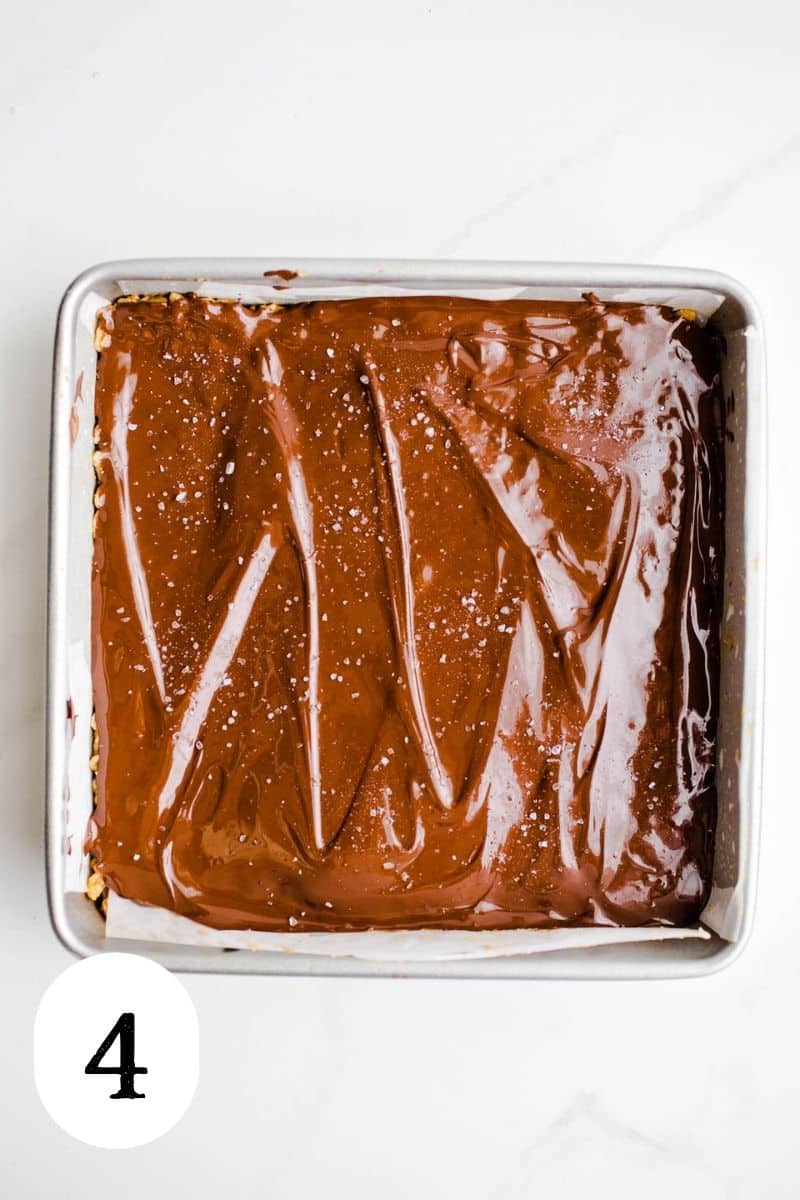 Freshly spread melted chocolate on top of bars in a baking pan.