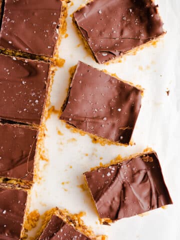 Sliced peanut butter chocolate bars on top of white parchment paper.