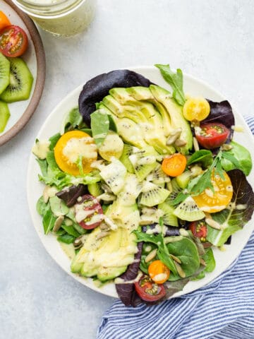 Quick and easy, this Kiwi, Avocado, and Tomato Salad recipe with Kiwi Dressing is sure to please. Gluten-free and vegan.