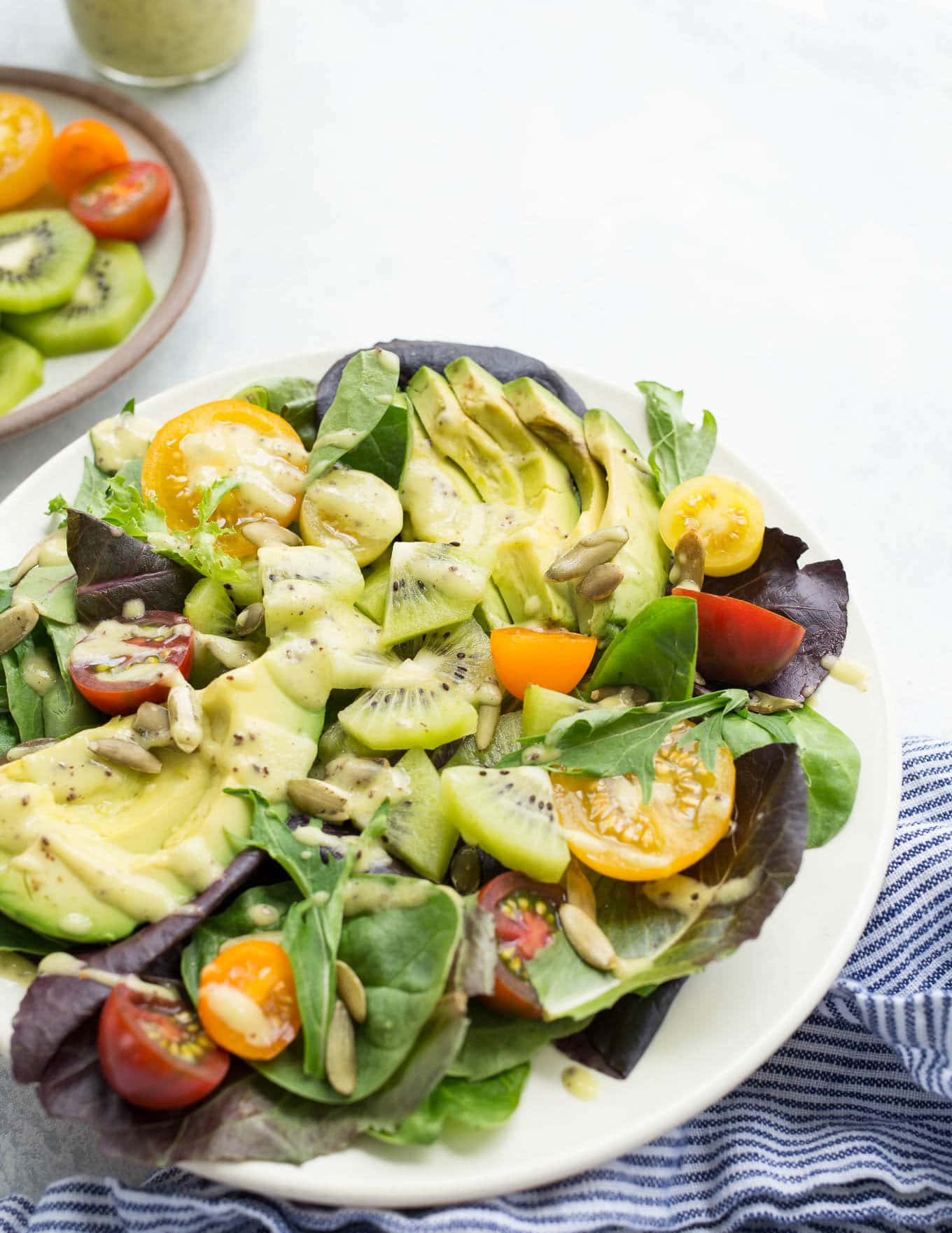 Bright, fresh, and easy, this Kiwi Avocado and Tomato Salad recipe is topped with a simple sweet and tangy kiwi fruit dressing. Gluten-free, vegan, and refined sugar-free. 