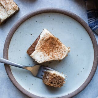 A slice of applesauce cake on a rustic plate.