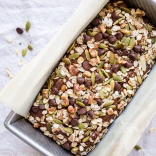 Quick bread with nuts and seeds in a loaf pan.