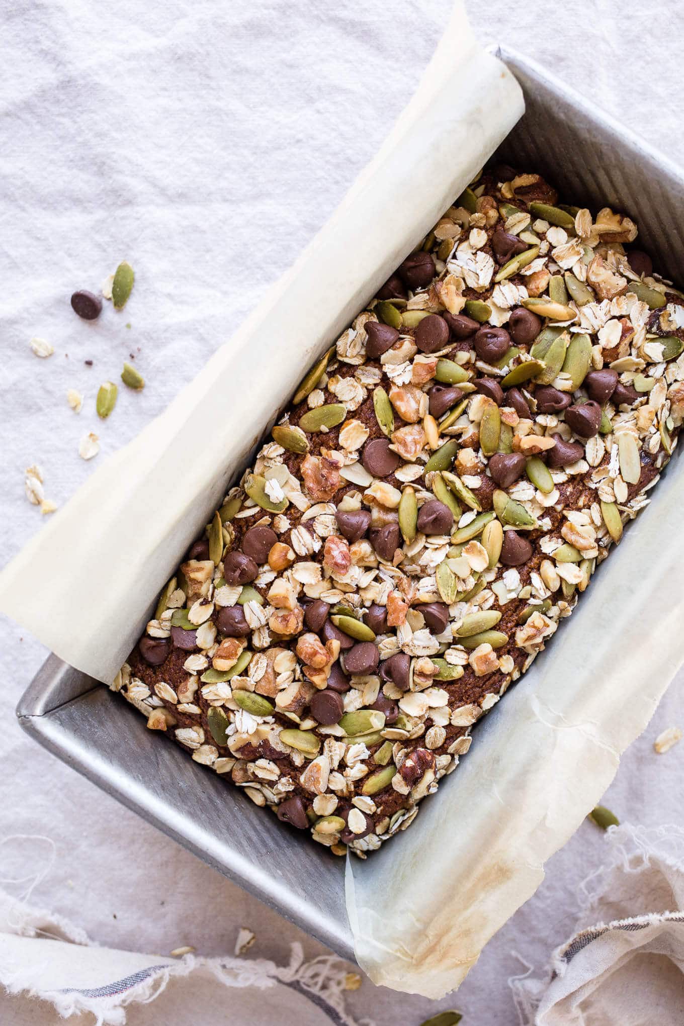 Quick bread with nuts and seeds in a loaf pan.