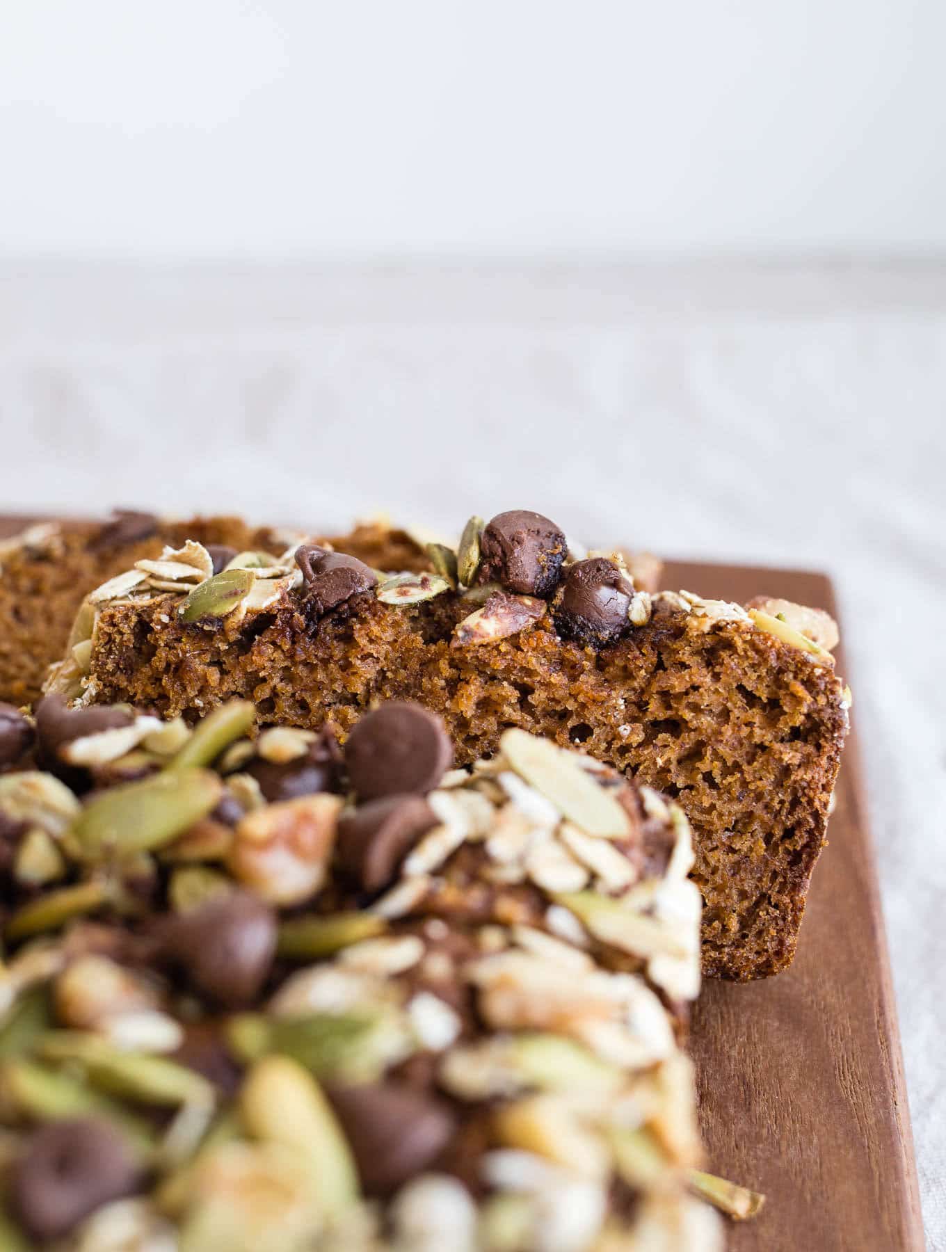 Healthy Sweet Potato Bread made with almond and oat flours, sweetened with maple syrup and sweet potato puree, warming spices, and topped with seeds, nuts, and chocolate chips. Gluten-free, dairy-free.
