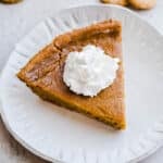 A slice of pumpkin pie on a plate.