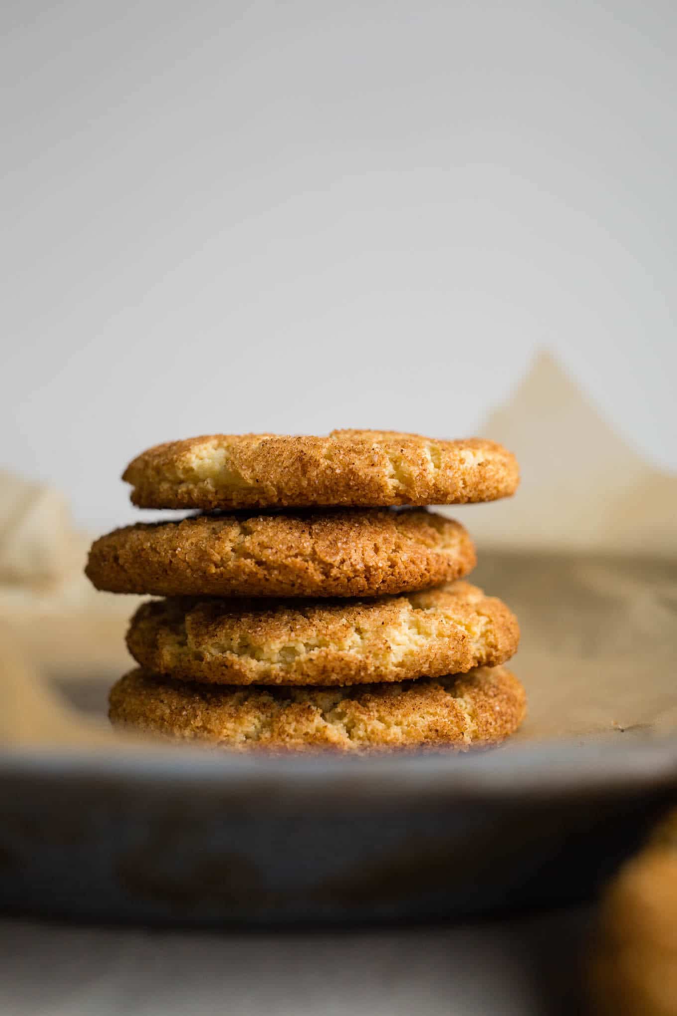 Snickerdoodle cookies stacked on a blue tray.