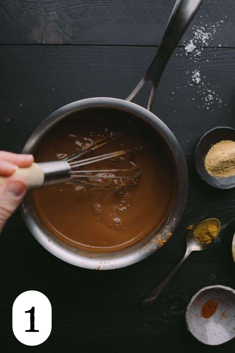 Whisking hot chocolate ingredients in a copper saucepan.