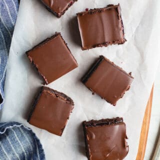 A layer of brownie, a layer of raspberry jam, and a layer of chocolate ganache make up these delicious Raspberry Truffle Brownies. Gluten-Free and vegan.