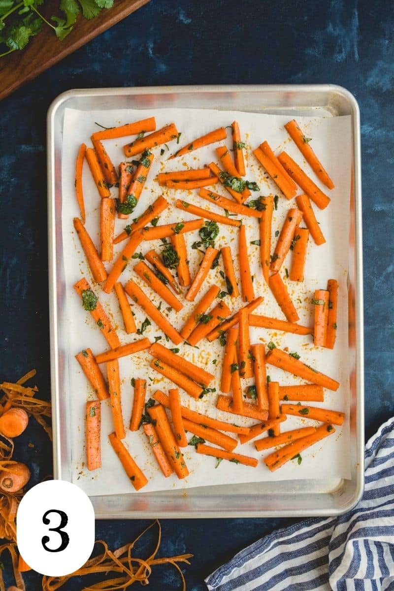 Seasoned carrots on a baking sheet. 