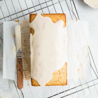 An iced pound cake on a wire rack.