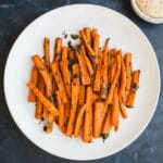 Oven Baked Carrot Fries tossed with olive oil, paprika, garlic powder, salt, pepper, and parsley, for a deliciously healthy snack recipe. Gluten-free, vegan.