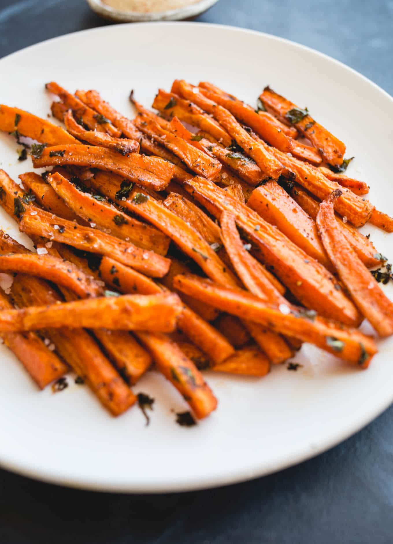 Oven Baked Carrot Fries tossed with olive oil, paprika, garlic powder, salt, pepper, and parsley, for a deliciously healthy snack recipe. Gluten-free, vegan. 