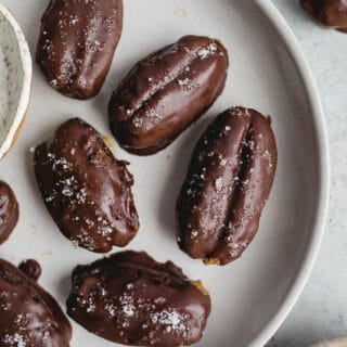 Chocolate covered dates on a gray plate.