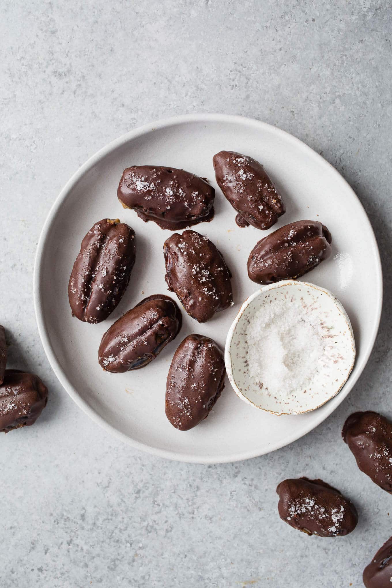 Dates covered with chocolate on a gray plate.