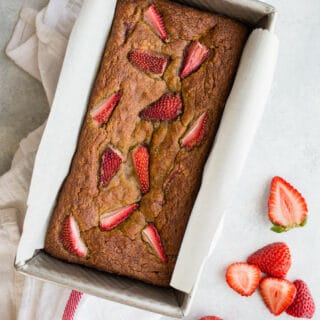 Roasted Strawberry Banana Bread made with almond flour, gluten-free oat flour, coconut sugar, ripe bananas, and topped with extra strawberries. A healthy banana bread recipe that is gluten-free, dairy-free, and refined sugar-free!