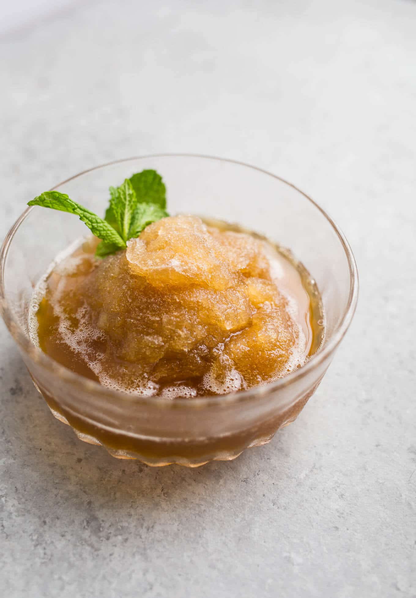 Mint Julep Granitas are made with a honey and mint infused simple syrup, bourbon, and are frozen until icy, flaked with a fork and frozen again. Served in a cup and garnished with mint.
